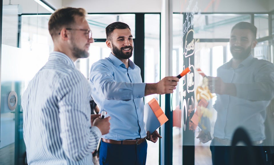 Zwei Prozessmanager brainstormen zur Prozessgestaltung an einem Whiteboard