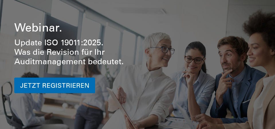 Eine Gruppe von fünf Personen steht in einem modernen Büro und diskutiert gemeinsam über Inhalte auf einem Tablet und Laptop. Eine ältere Frau mit Kurzhaarschnitt und Brille spricht und gestikuliert, während die anderen aufmerksam zuhören.