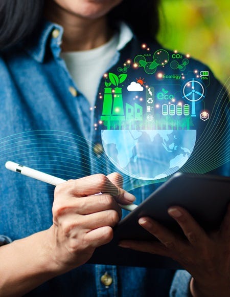 Frau macht Notizen auf einem mobilen Device + Net-Zero-Symbole zu reduzierten CO2-Emissionen und grüner Produktion