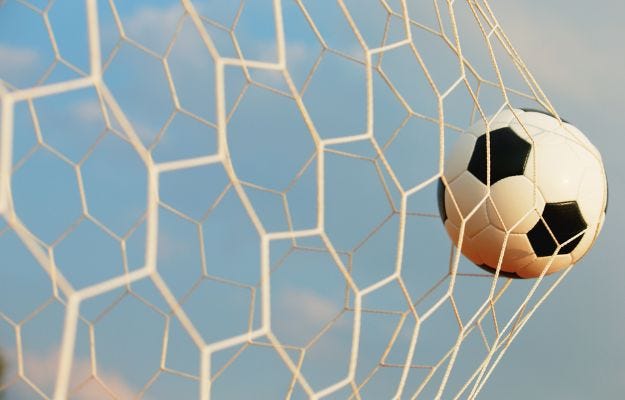 Frauen-EM 2029 in Hannover Ein Stadion im Dämmerlicht. Das Bild zeigt einen Ausschnitt vom Rasen und den dahinterliegenden Tribpnen mit vollen Rängen.