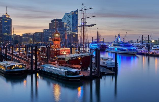 Die Hamburger Hafenstadt bei D&auml;mmerung. Die Elbphilharmonie ist mit einigen Schifften davor auf der Elbe zu sehen.