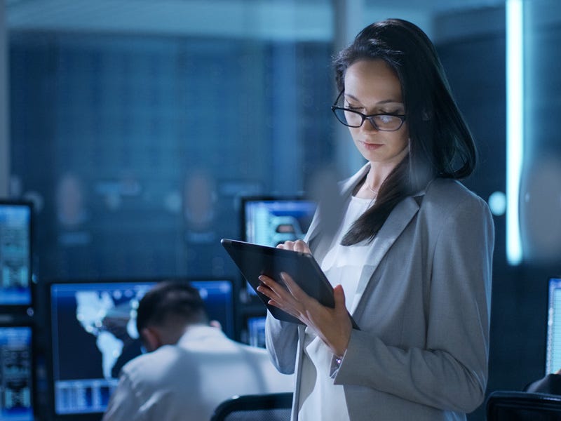 Unsere Weiterbildungen in Hannover vermitteln IT / Informationstechnologie Fachkenntnisse Frau mit grauem Blazer hält ein Computer-Tablet