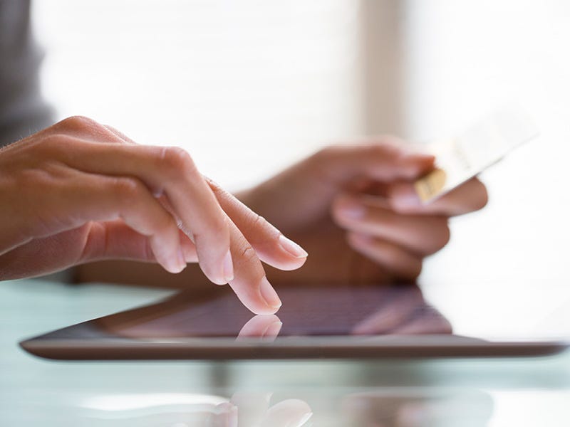 Weiterbildung Hannover Nahaufnahme von zwei Händen die ein auf dem Tisch liegendes Tablet bedienen