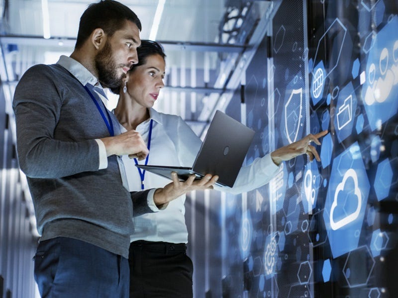 Zwei Expert:innen arbeiten gemeinsam an cloudbasierten Lösungen an einem modernen Board – ein Sinnbild für vernetzte Daten, smarte Technologien und die Zukunft der Digitalisierung.