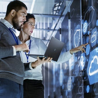 Zwei Expert:innen arbeiten gemeinsam an cloudbasierten Lösungen an einem modernen Board – ein Sinnbild für vernetzte Daten, smarte Technologien und die Zukunft der Digitalisierung.