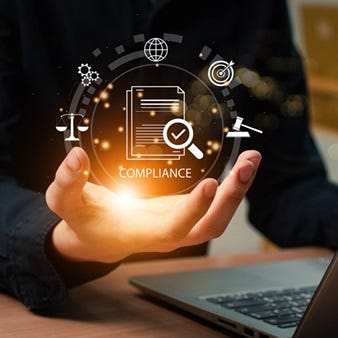 Symbolische Darstellung von Compliance und rechtlicher Sicherheit: Eine Hand hält eine leuchtende digitale Darstellung von Vorschriften, Gesetzessymbolen und Kontrollmechanismen, während im Hintergrund ein Laptop für die digitale Umsetzung steht.