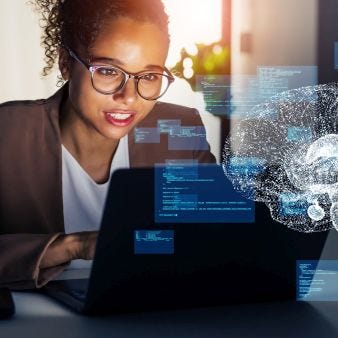 Frau mit Brille sitzt vorm Laptop