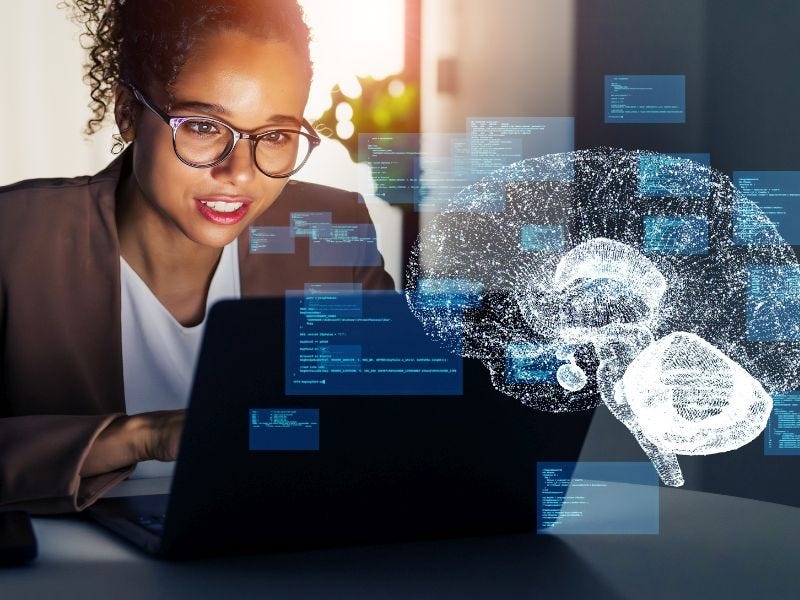 Frau mit Brille sitzt vorm Laptop