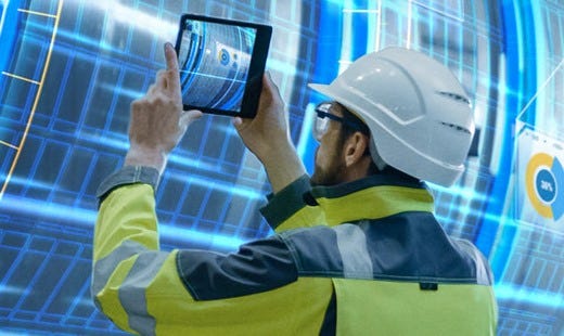 Mann mit Helm und Arbeitsschutz-Kleidung hält ein Tablet in der Hand, um Fotos damit zu machen.