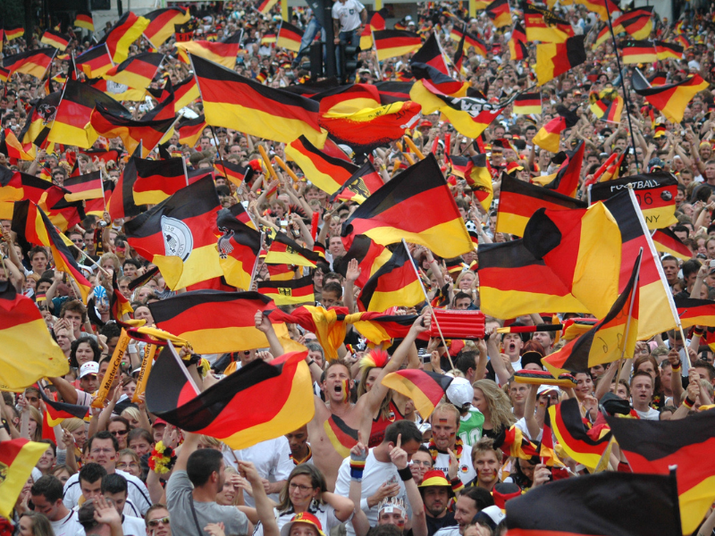 Fußballfans der deutschen Nationalmannschaft jubeln in der Menge.