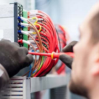 Mann prüft elektrische Verbindungen Mann prüft elektrische Verbindungen
