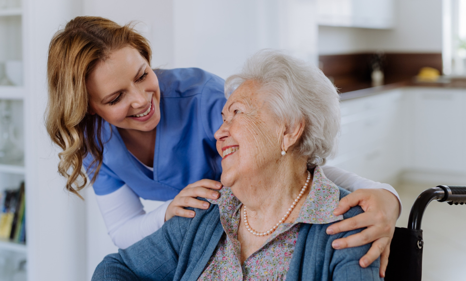 Eine Pflegekraft lächelt eine Patientin an.