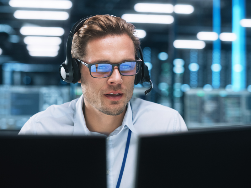 ein jünger Mann an zwei Bildschirmen