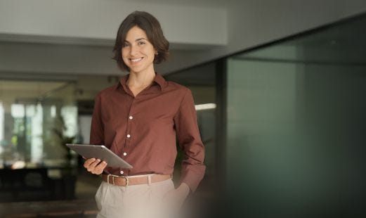 L&auml;chelnde Frau mit Tablet im B&uuml;ro