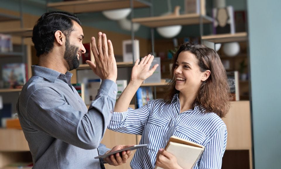 Ein Mann und eine Frau lächeln und geben High Five