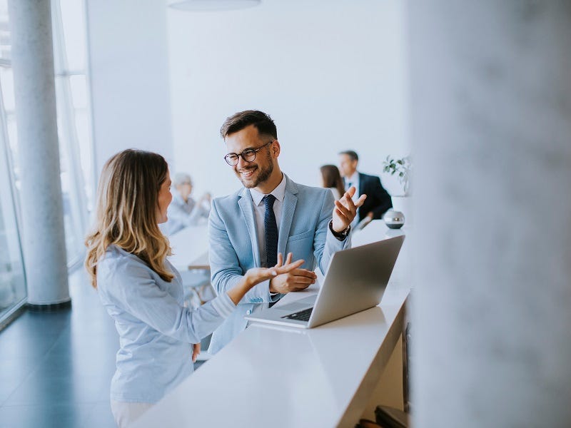 Ein Mann und eine Frau stehen an einem Stehtisch und unterhalten sich