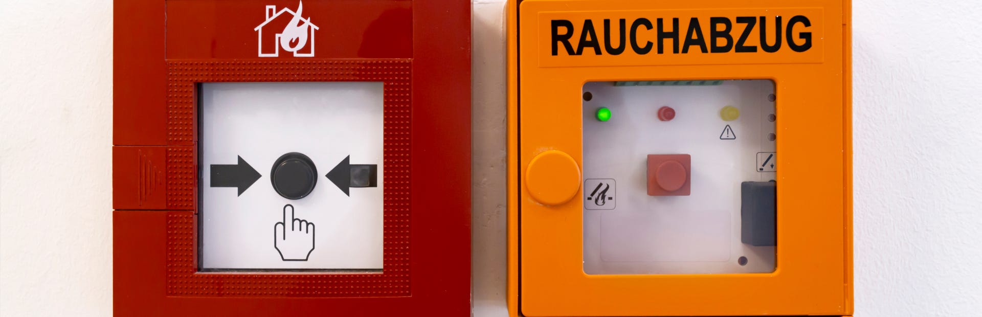 Eine Frau und ein Mann mittleren Alters schauen gemeinsam auf ein Blatt Papier. Der Mann hat einen Laptop vor sich, schaut jedoch auf das Papier, welches die Frau in der Hand hält. Sie sitzen in einem hellen Büro mit vielen Fenstern.