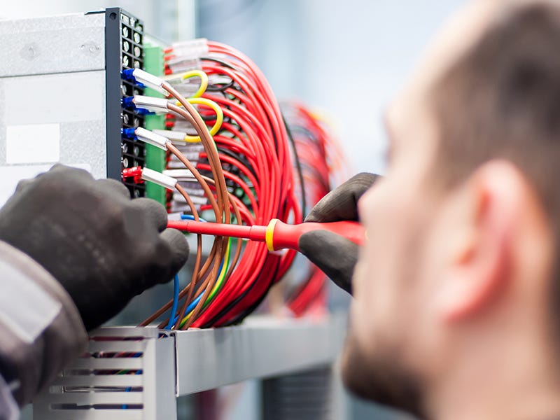 Mann prüft elektrische Verbindungen Mann prüft elektrische Verbindungen