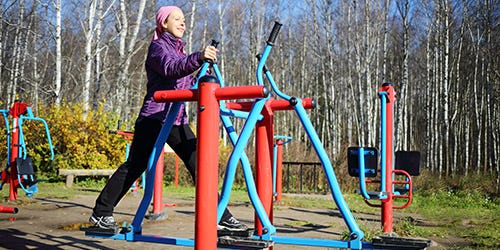 Frau auf einem Fitnessgerät im Freien