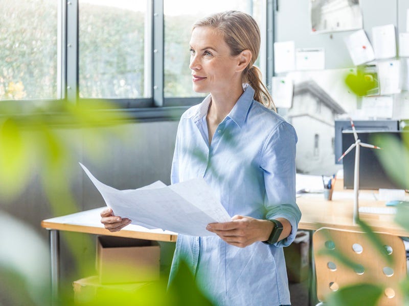 Frau in einem Büro mit Dokumenten in der Hand