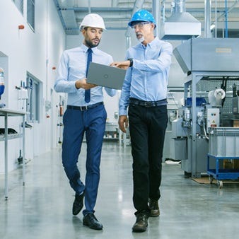 Zwei Klimaschutz-Verantwortliche in einer Produktionshalle