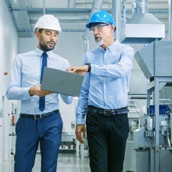 Zwei Energieverantwortliche analysieren Energiekennzahlen am Laptop