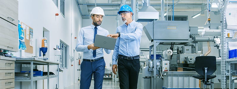 Zwei Energieverantwortliche analysieren Energiekennzahlen am Laptop