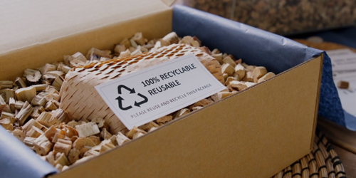 Versandkarton mit Verpackungsmaterial aus recycelbarem Papier mit Hinweis auf nachhaltige Verpackung.