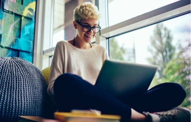Zwei Frauen im Gro&szlig;raumb&uuml;ro besprechen Dokumente mit einer Tasse Kaffee