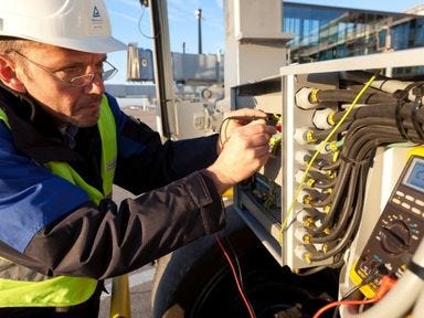 Elektrofachkraft pr&uuml;ft mit Messger&auml;t elektrische Anschl&uuml;sse an einer Anlage.
